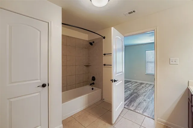 a bathroom with a tub shower and sink