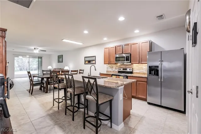 a kitchen with stainless steel appliances granite countertop a sink and a refrigerator