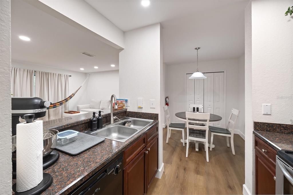 3705 Southwest 27th Street, Unit 913 Gainesville, FL 32608 - Photo 15 of 50 a kitchen with furniture wooden floor and stainless steel appliances