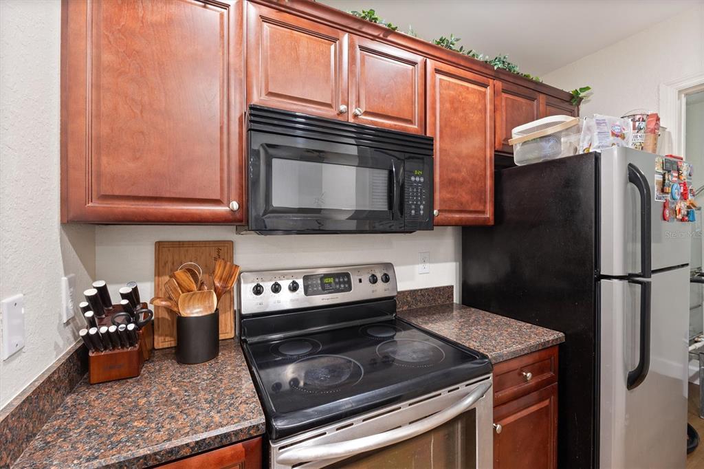 3705 Southwest 27th Street, Unit 913 Gainesville, FL 32608 - Photo 20 of 50 a kitchen with stainless steel appliances granite countertop a refrigerator stove and microwave