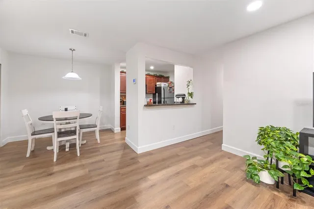 a view of a kitchen with wooden floor and a dining table