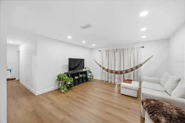 a living room with furniture a wooden floor and a flat screen tv