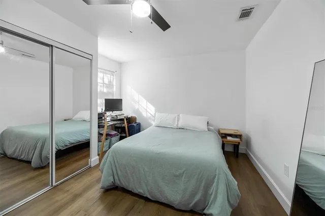 a bedroom with a bed and wooden floor