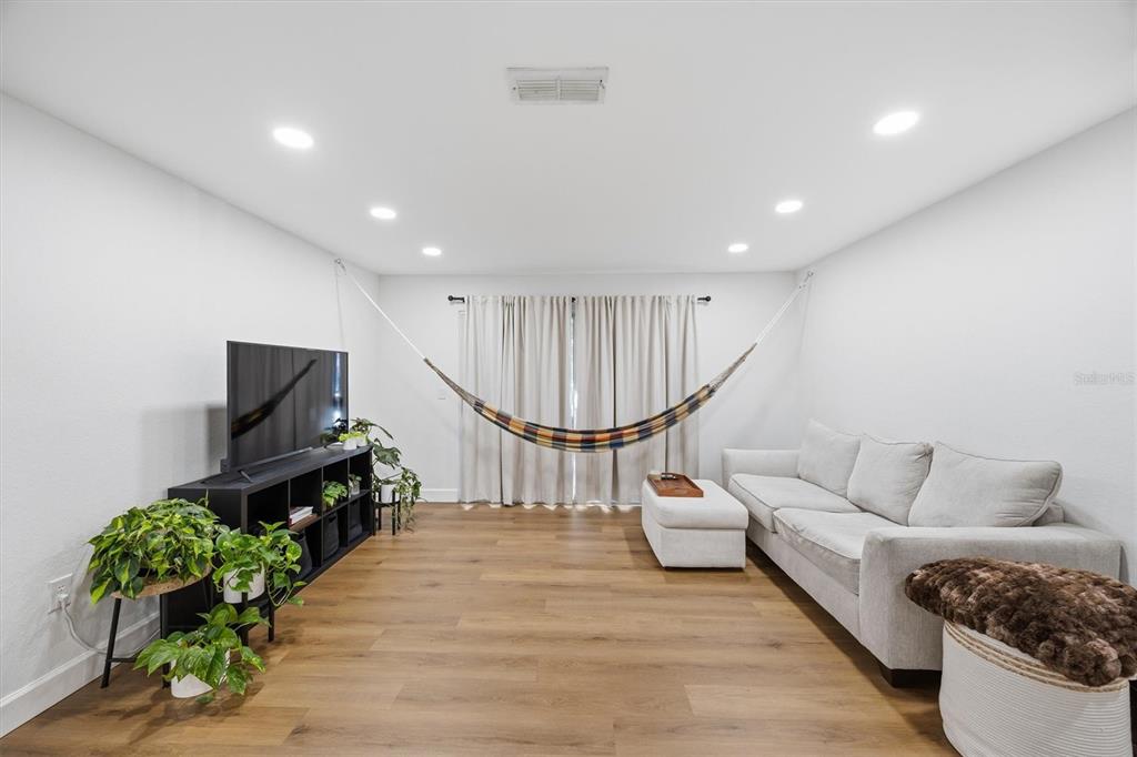 3705 Southwest 27th Street, Unit 913 Gainesville, FL 32608 - Photo 8 of 50 a living room with furniture a wooden floor and a chandelier