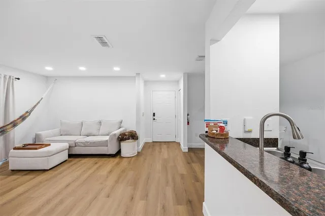 a living room with furniture and a wooden floor