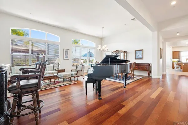 a living room with furniture and a dining table with wooden floor