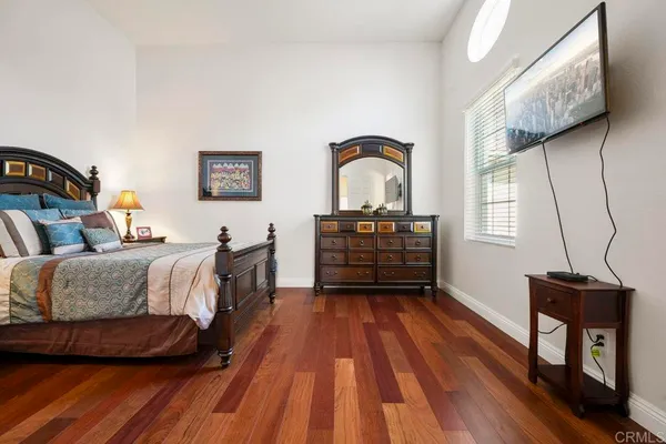 a bedroom with a bed and a dresser next to a window