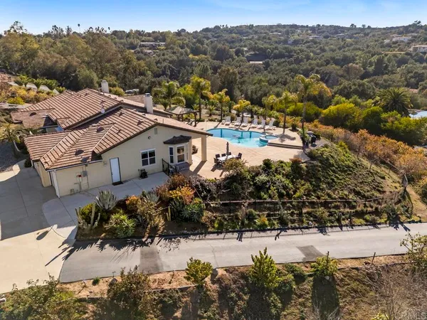 an aerial view of residential houses with outdoor space and trees