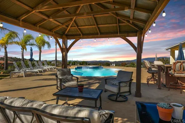 a view of a swimming pool with lounge chairs in patio