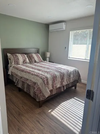 a bed sitting in a bedroom next to a wooden cabinet
