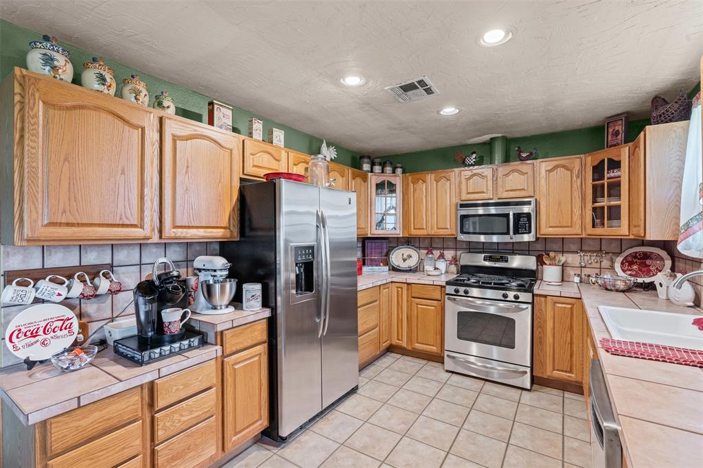 14522 Southwest County Road 4140 Dawson, TX 76639 - Photo 13 of 40 a kitchen with stainless steel appliances granite countertop a refrigerator stove and sink