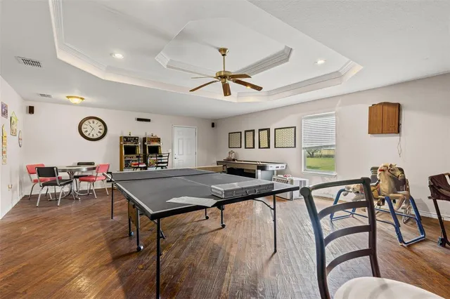 a living room with furniture a piano and a ceiling fan