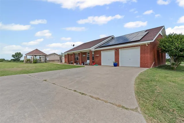 a view of a house with a big yard and potted plants