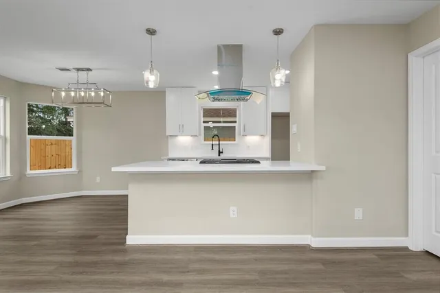 a view of a kitchen counter space a sink wooden floor and a window
