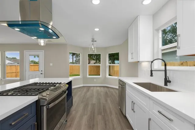 a kitchen with a sink stove and cabinets