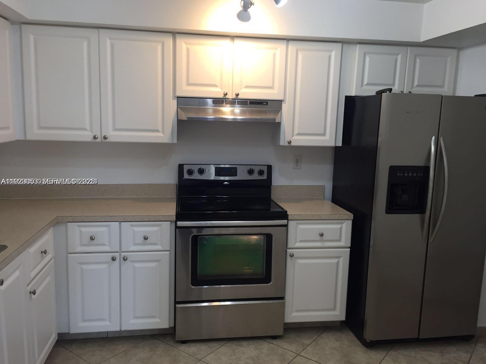 a kitchen with stainless steel appliances white cabinets and a refrigerator