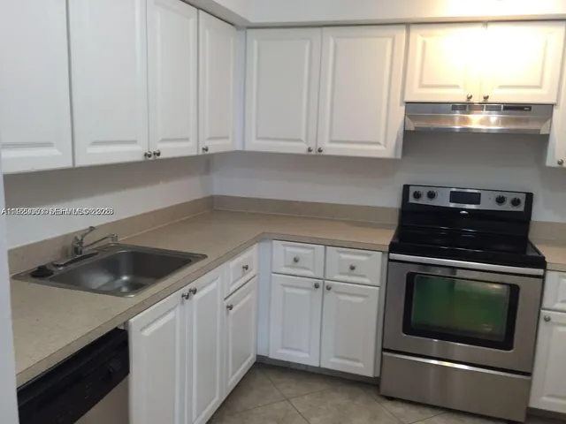 a kitchen with white cabinets and a stove top oven