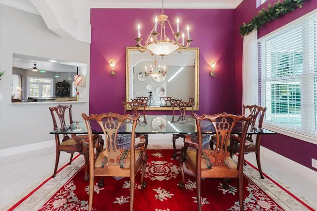 a dining room with furniture a chandelier and wooden floor