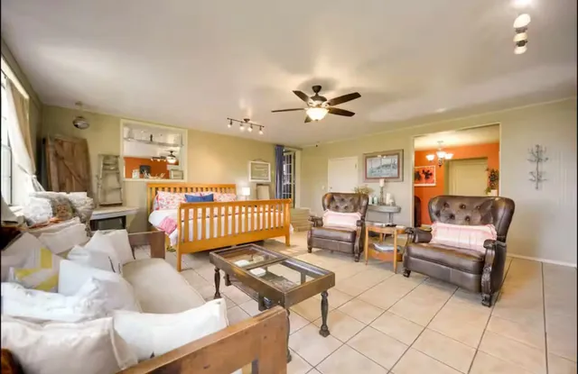 a living room with furniture a flat screen tv and a large window