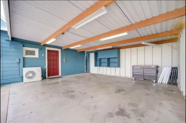a view of a house with a yard and large tree