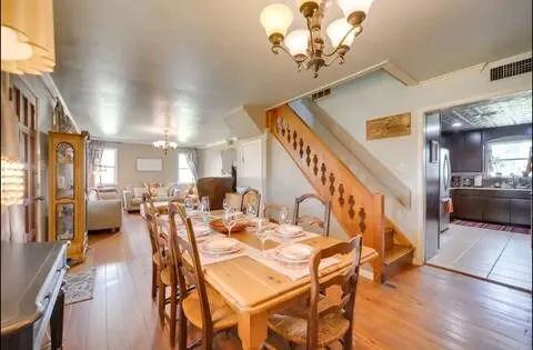 a view of a dining room with furniture a chandelier and wooden floor