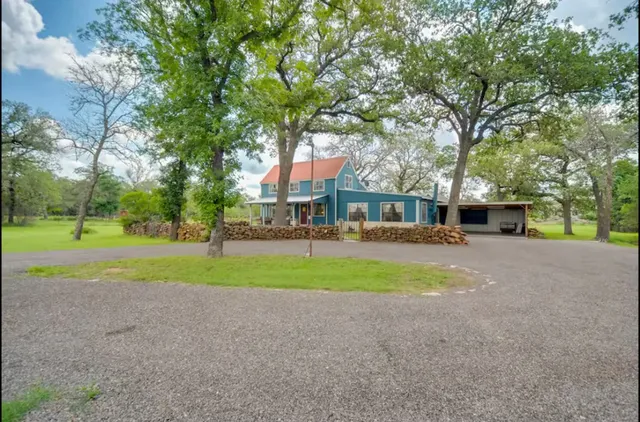 a view of a house with swimming pool next to a big yard