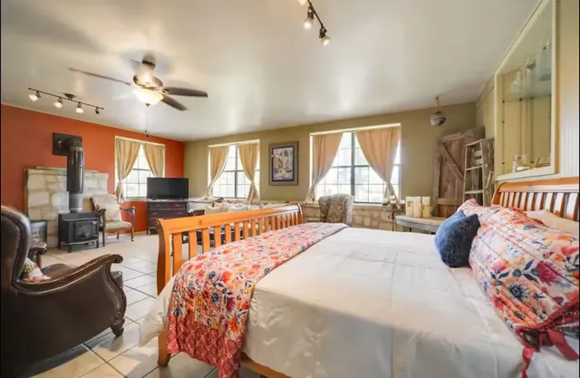 a bedroom with a bed a couch and dresser