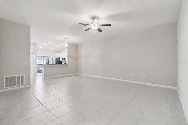 an empty room with a ceiling fan and a window
