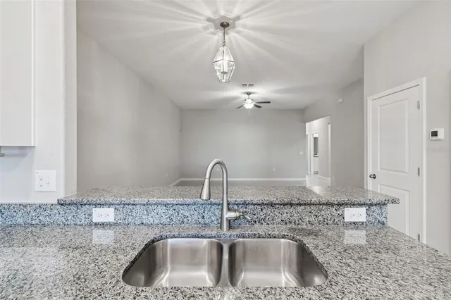 a view of a hallway to an empty room and window