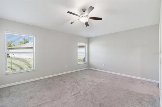 an empty room with closet and a ceiling fan