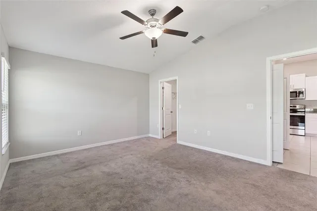 a view of an empty room with a ceiling fan