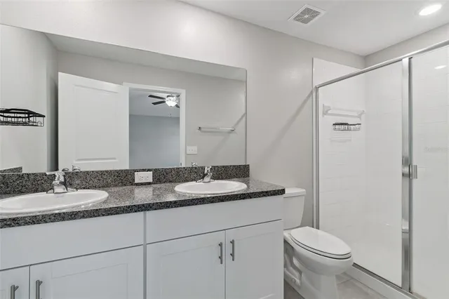 a bathroom with a granite countertop sink toilet and shower