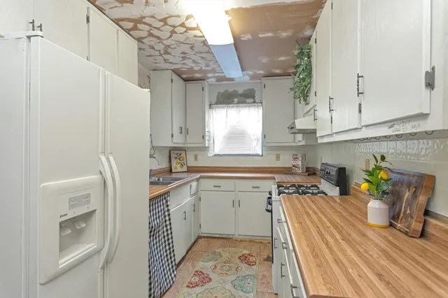 a bedroom with a bed chandelier and a window