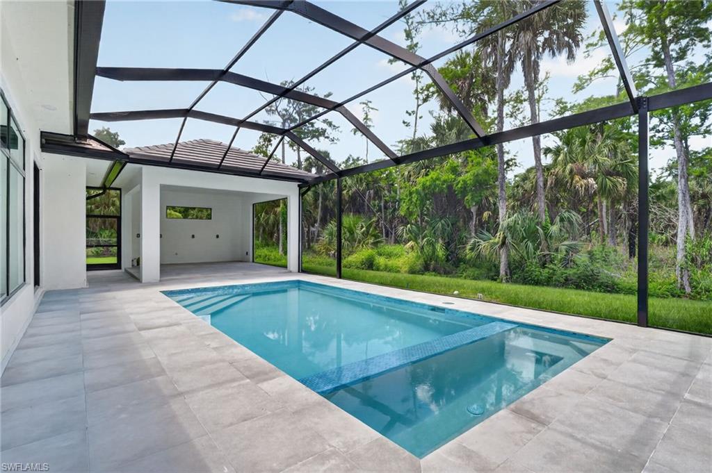 563 15th Street Northwest Naples, FL 34120 - Photo 18 of 22 a view of a swimming pool with a backyard