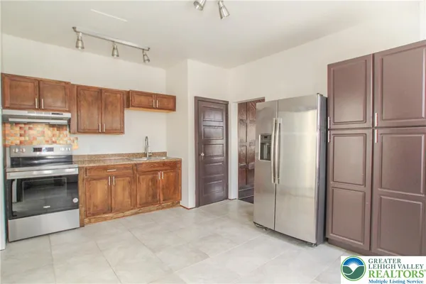 a kitchen with stainless steel appliances granite countertop a refrigerator and a stove top oven