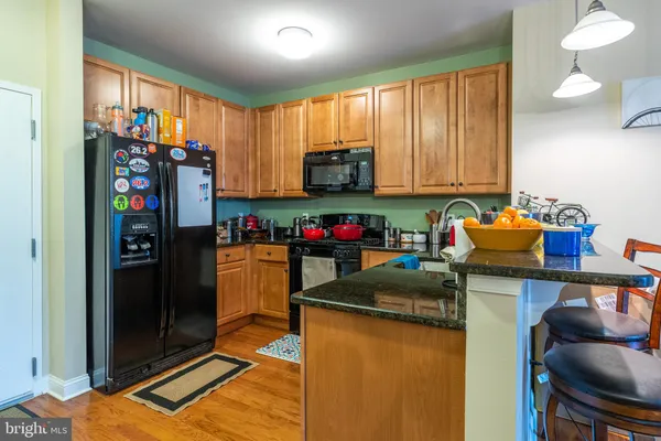 a kitchen with a refrigerator and a stove top oven
