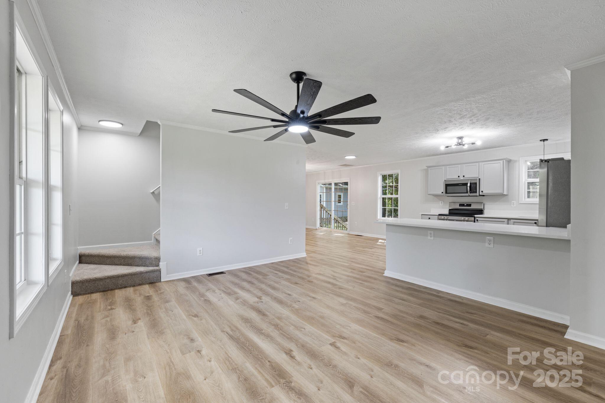6708 Rebel Road Marshville, NC 28103 - Photo 8 of 41 a view of a kitchen with wooden floor and a ceiling fan