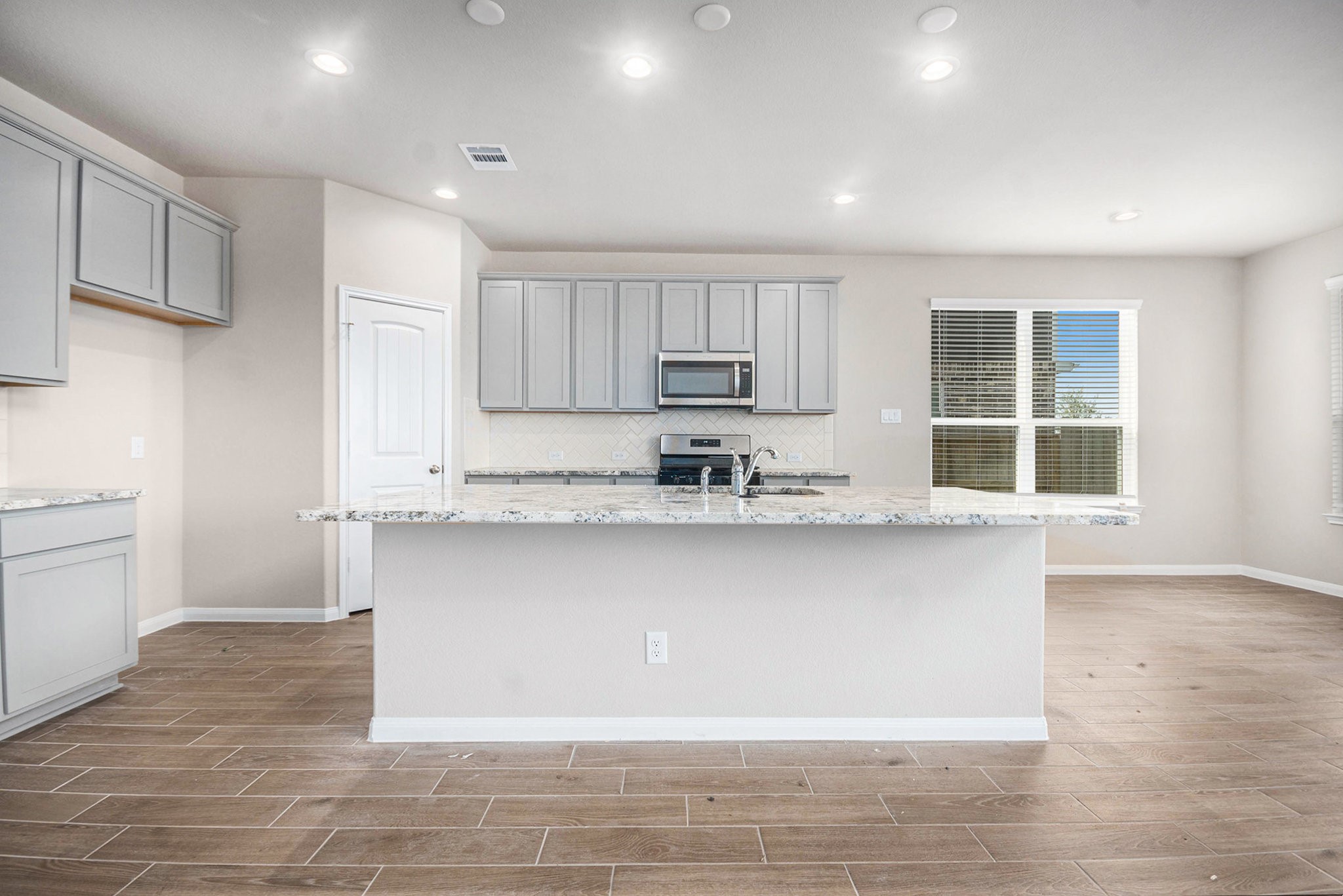 25 Carmel Drive Manvel, TX 77578 - Photo 16 of 50 a kitchen with stainless steel appliances granite countertop a stove a sink and a microwave