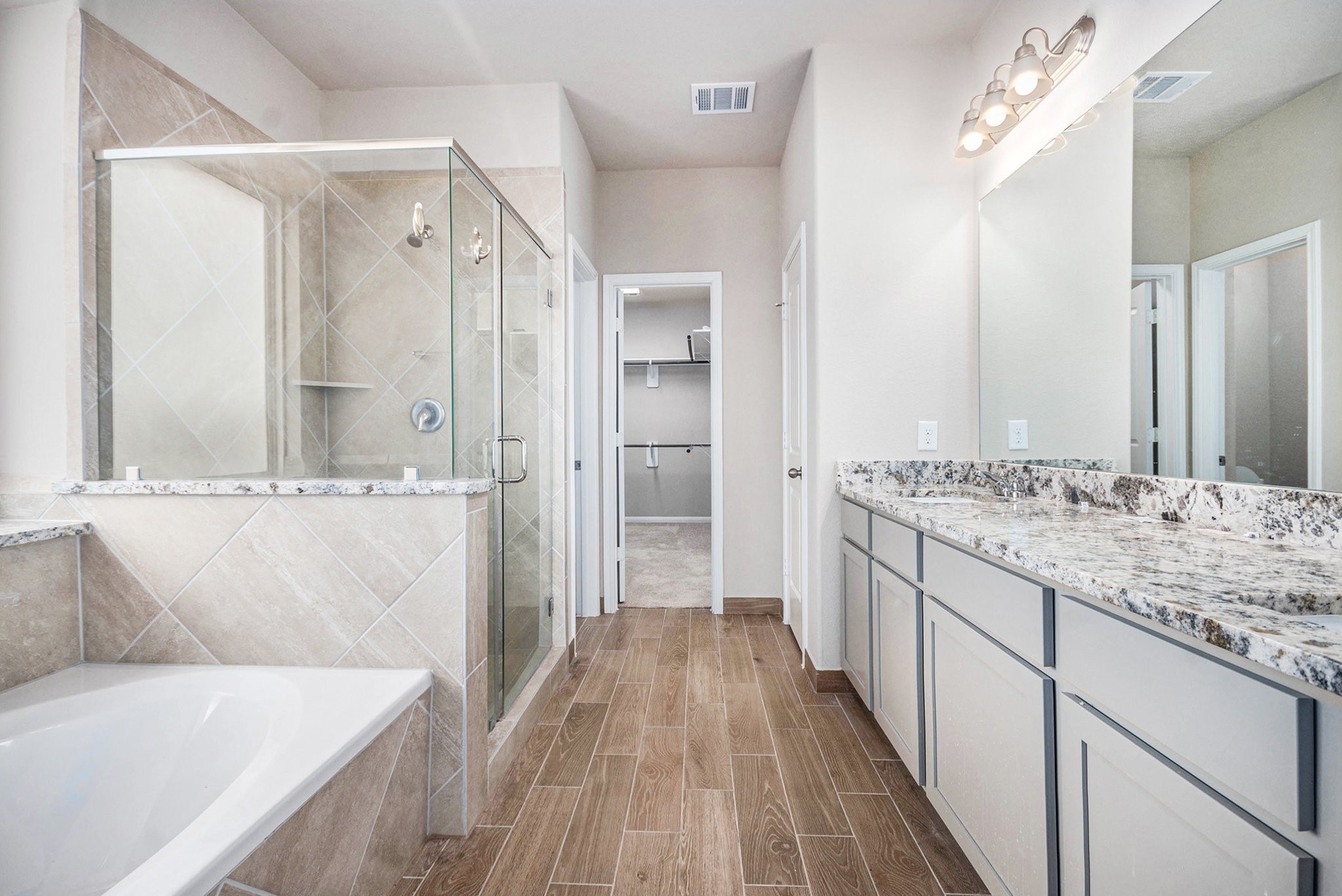 25 Carmel Drive Manvel, TX 77578 - Photo 20 of 50 a bathroom with a granite countertop sink a toilet a large mirror a bathtub and shower