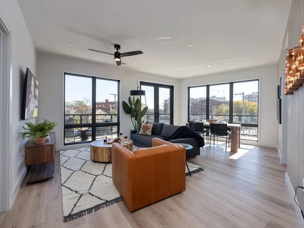 a living room with furniture and floor to ceiling windows