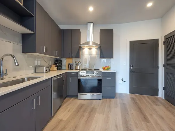 a kitchen with stainless steel appliances granite countertop a sink stove and refrigerator