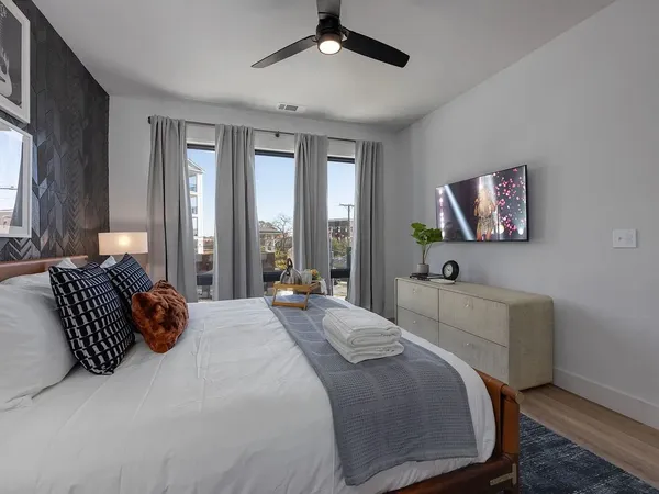 a spacious bedroom with a bed and glass walk in closet