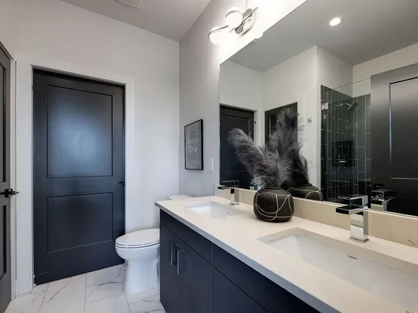 a bathroom with a double vanity sink toilet and shower