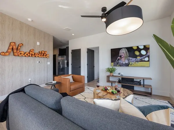 a living room with furniture kitchen and a mirror