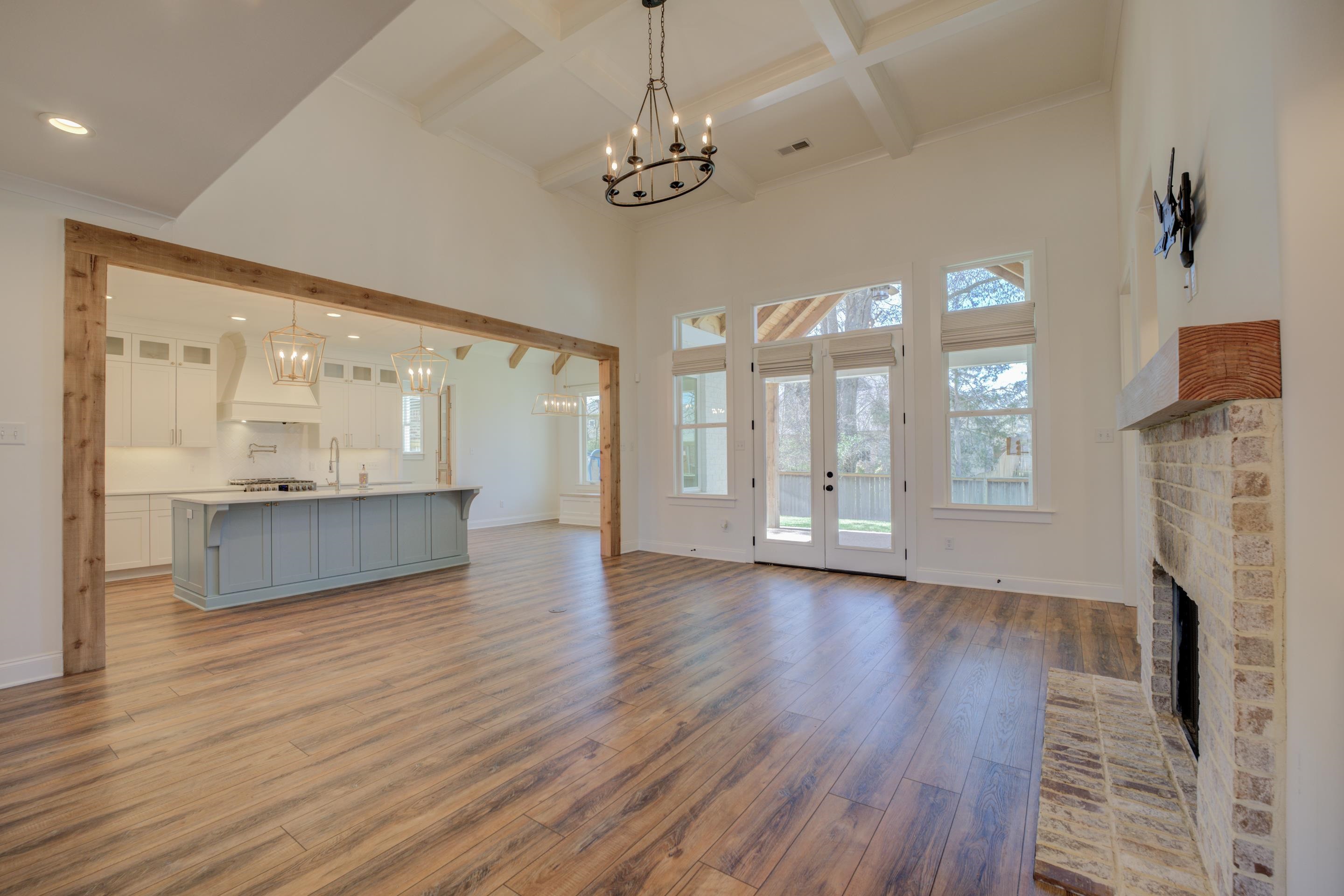 1373 Belfair Drive Collierville, TN 38017 - Photo 13 of 24 a view of an empty room with wooden floor and a kitchen