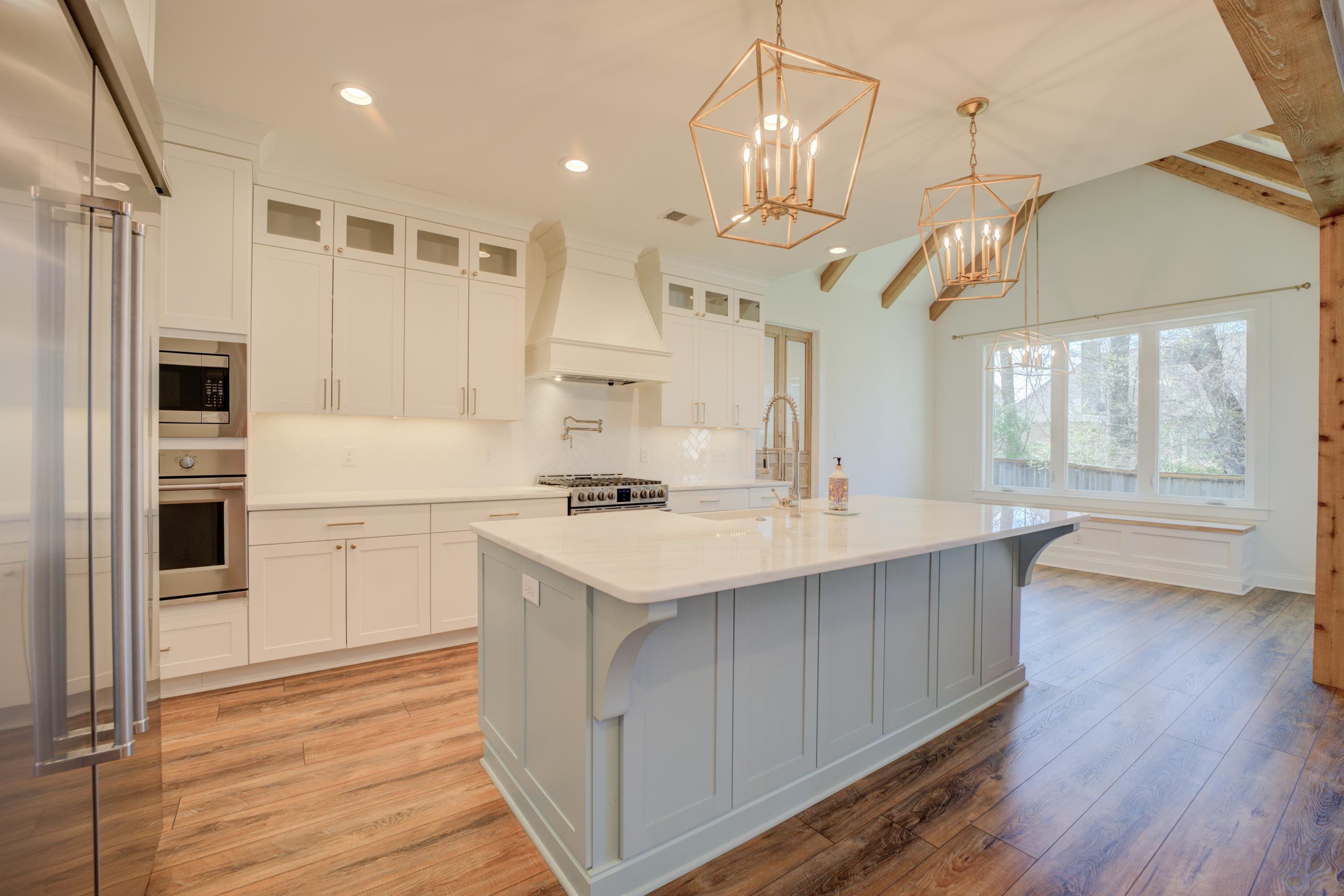 1373 Belfair Drive Collierville, TN 38017 - Photo 5 of 24 Kitchen featuring white cabinets, built in appliances, glass insert cabinets, decorative light fixtures, and light wood finished floors