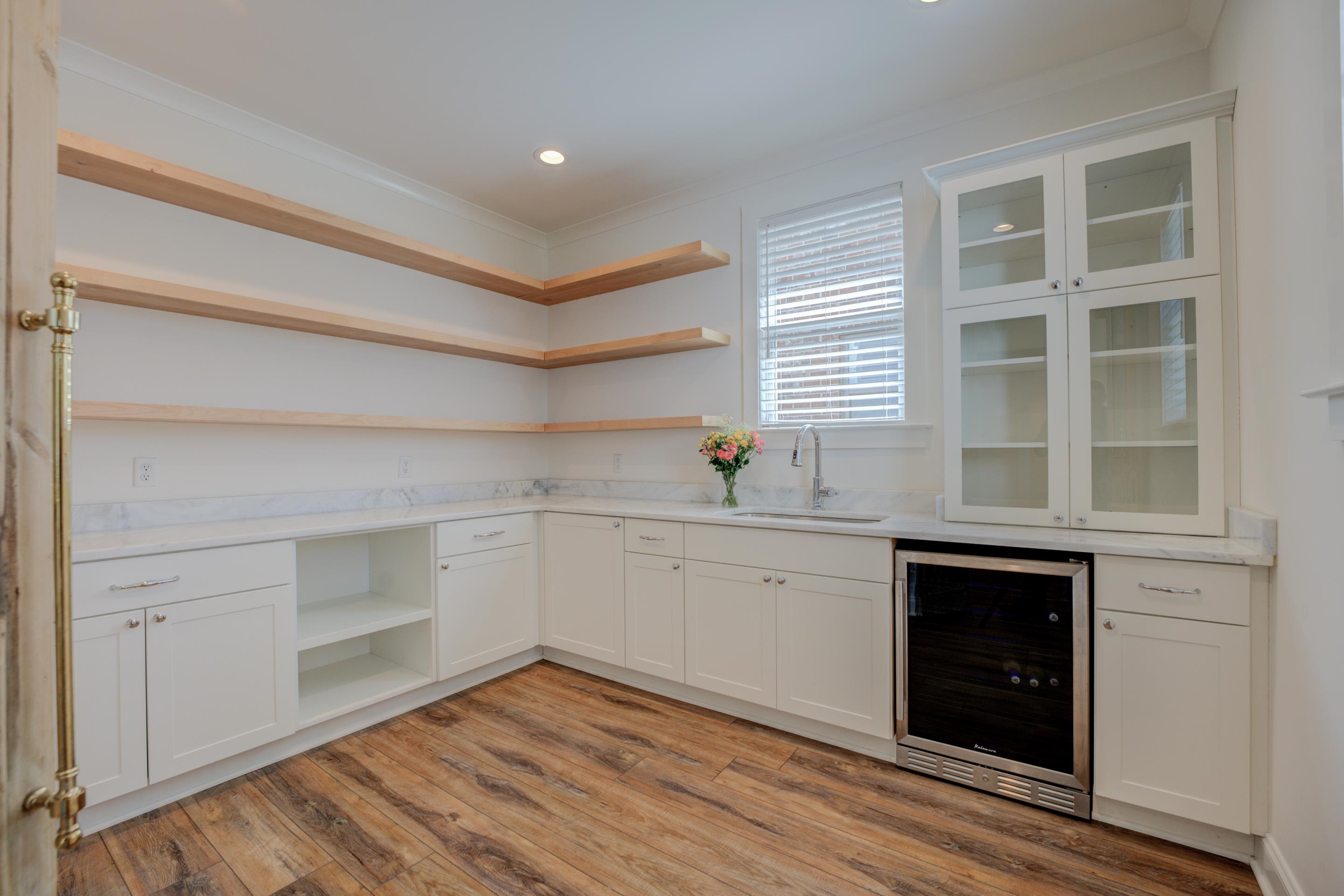 1373 Belfair Drive Collierville, TN 38017 - Photo 9 of 24 Indoor wet bar featuring open shelves, white cabinets, wine cooler, ornamental molding, and light wood-style floors
