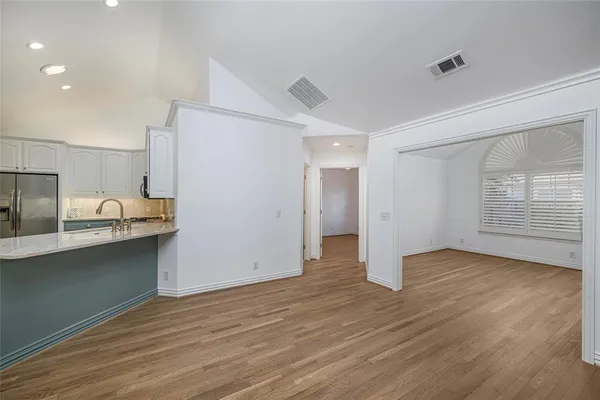 a view of a kitchen with wooden floor and electronic appliances