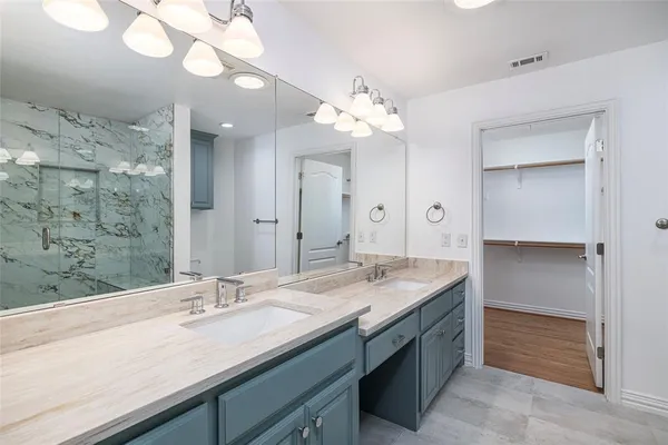 a bathroom with a granite countertop sink a large mirror and a shower