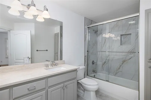 a bathroom with a sink a toilet and a large mirror